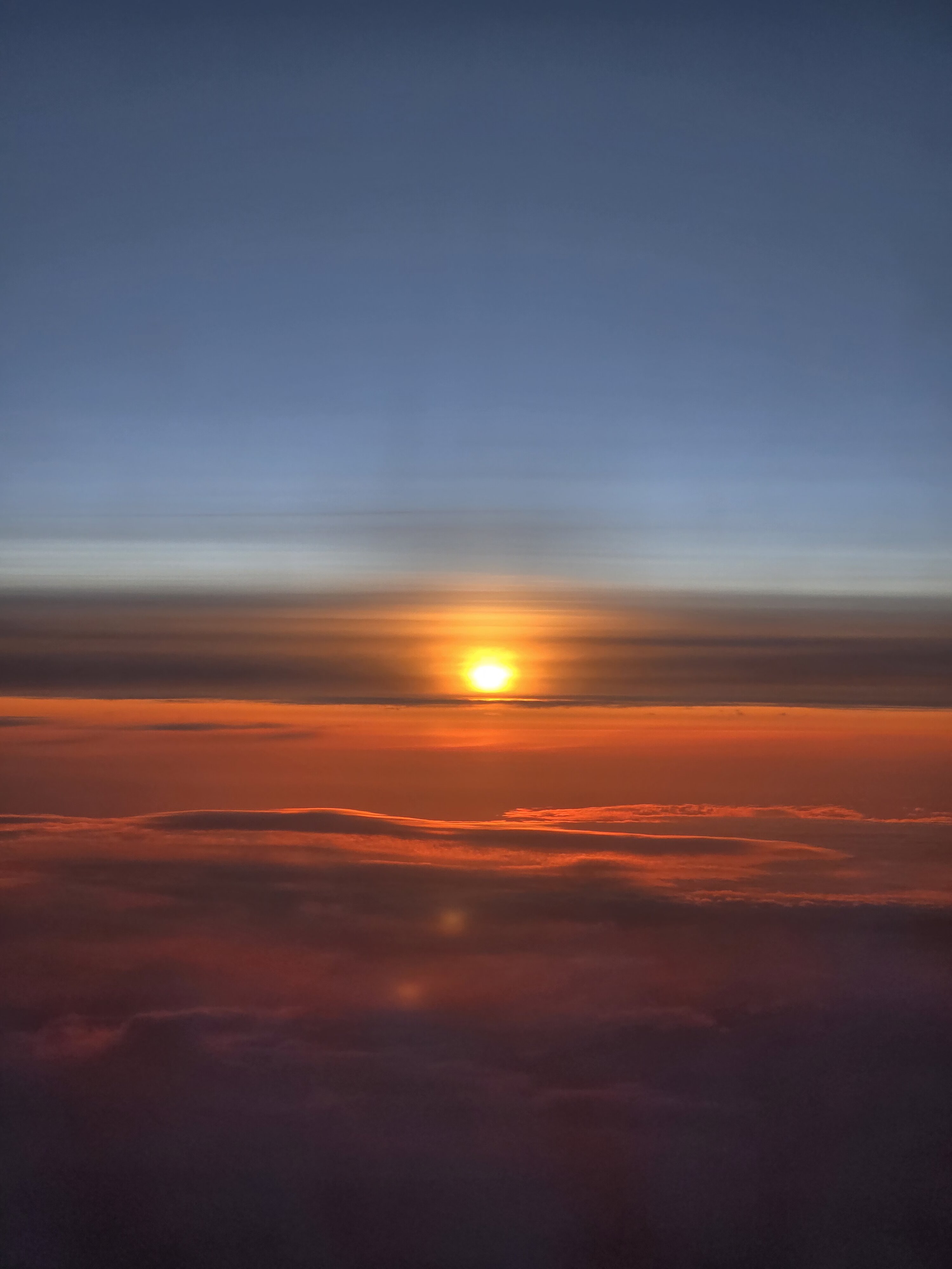 Aerial view of a bright sunset above layered clouds