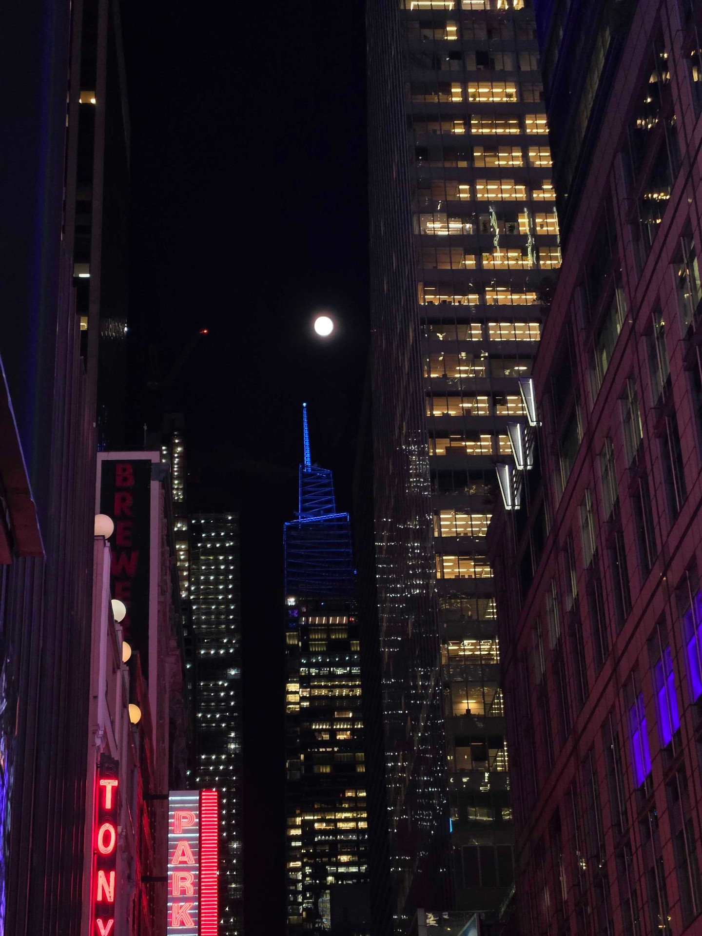 City skyline at night with full moon